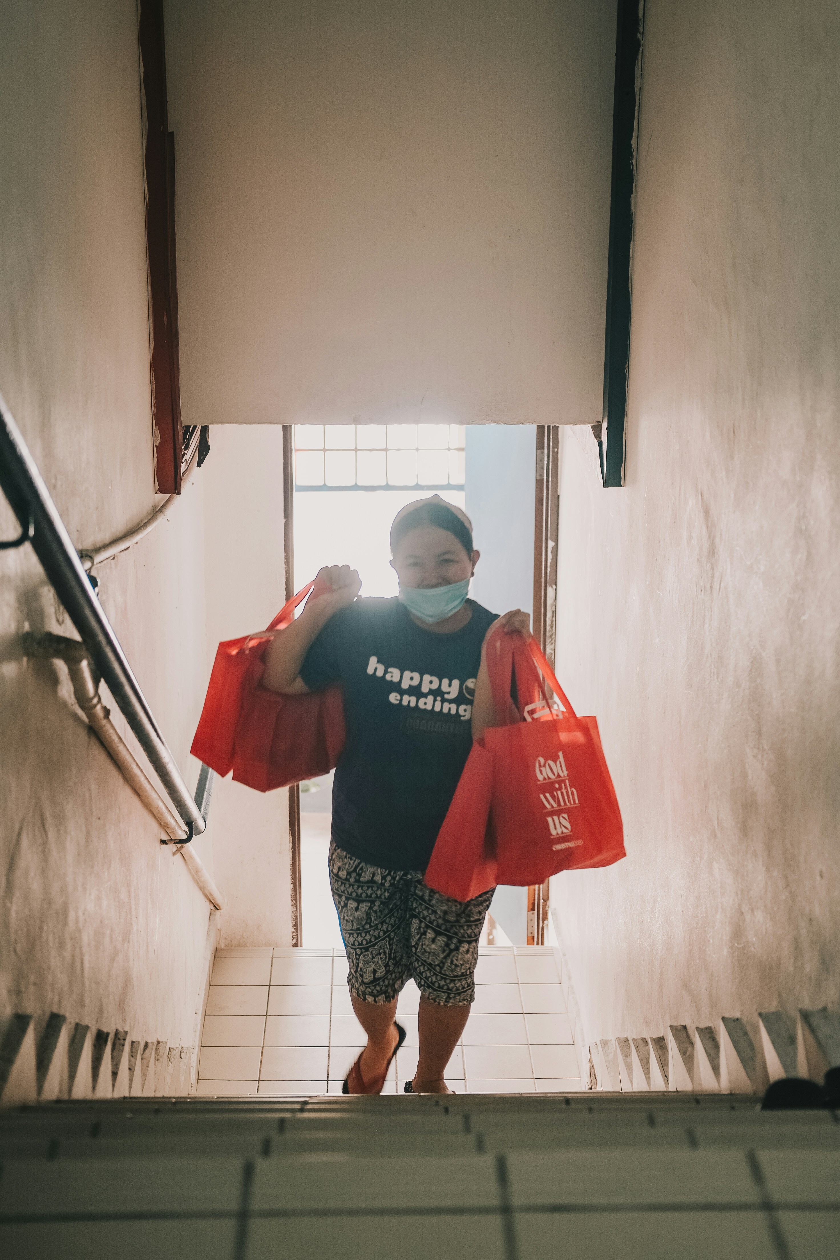 woman in red and black long sleeve shirt holding red tote bag